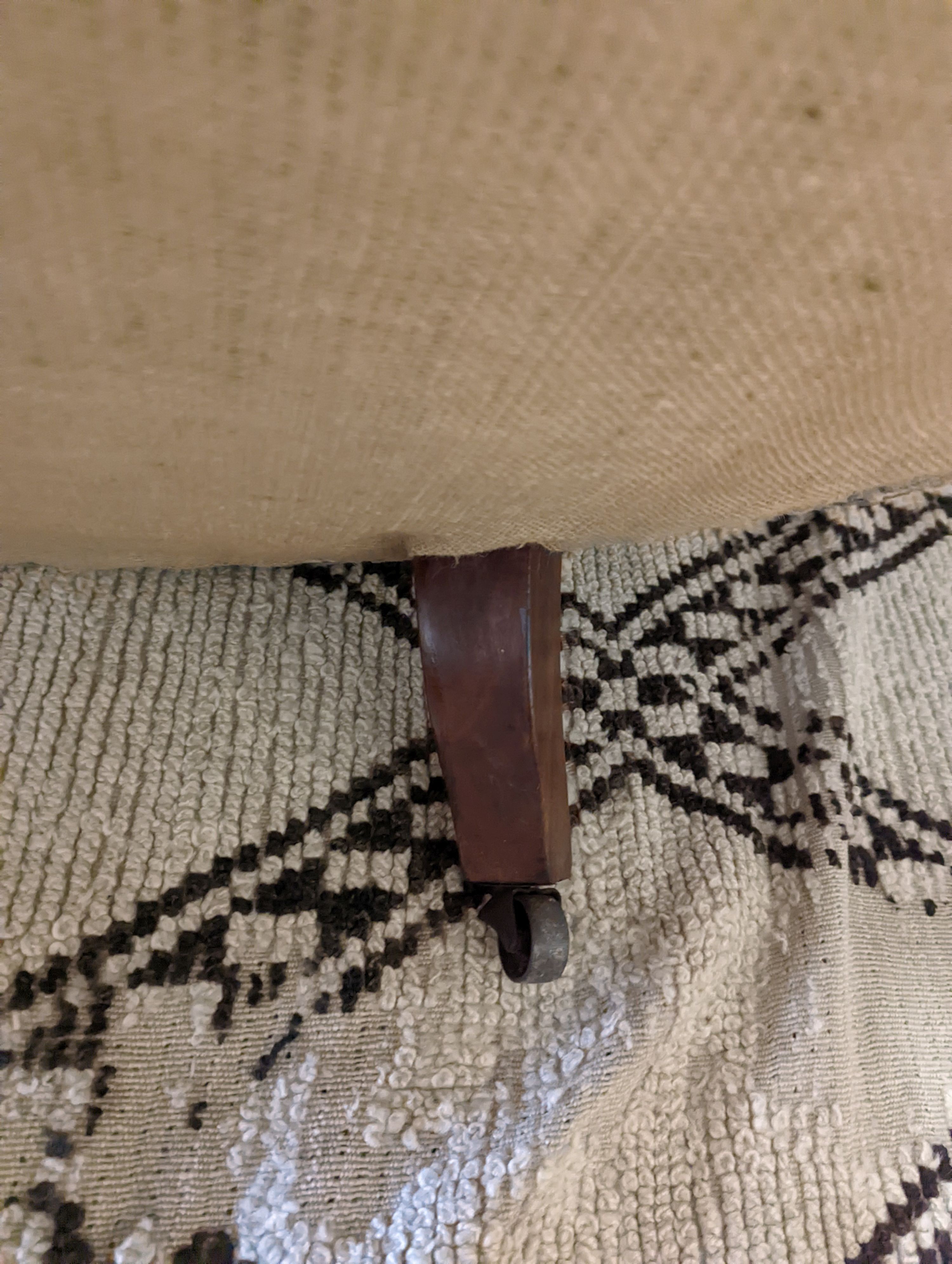 A Victorian upholstered settee with turned walnut legs, fitted brass castors, length 188cm